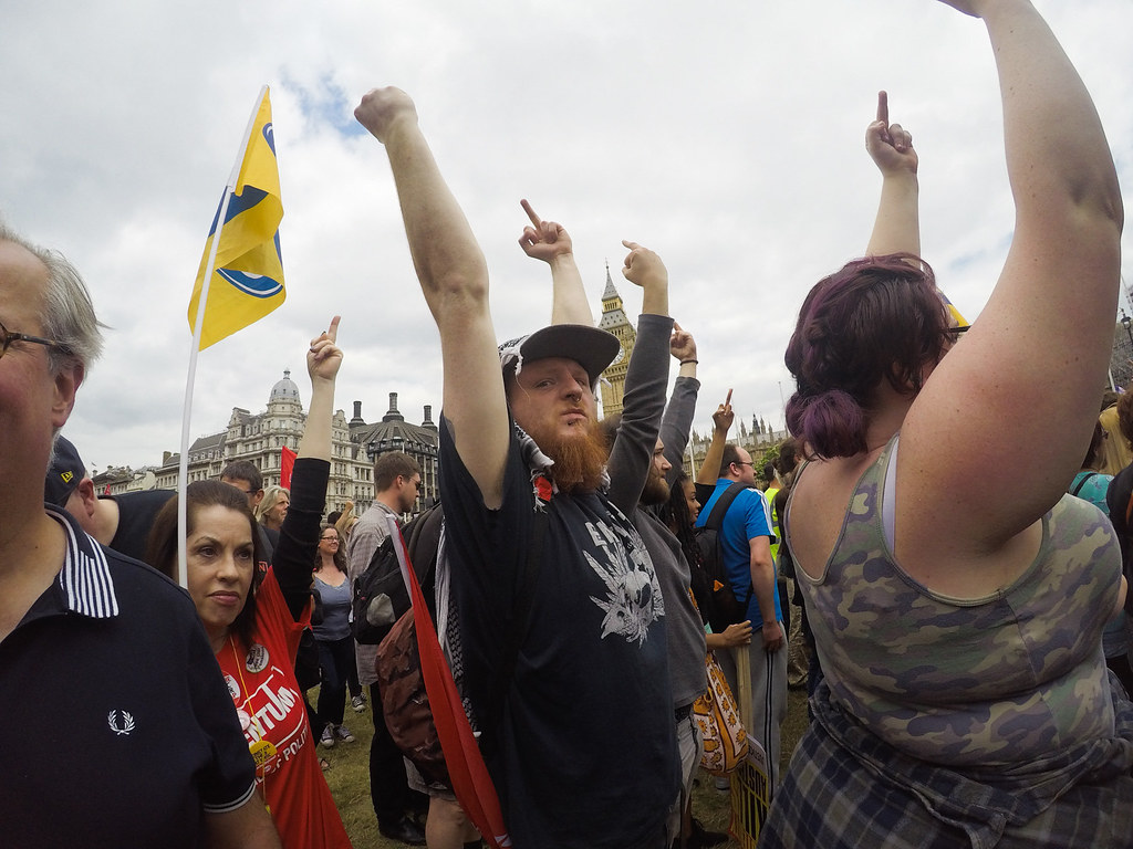 Braccia alzate a una manifestazione a Londra, sullo sfondo il Big Ben